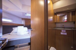 A compact bedroom with a bed, a small desk, and a mirror. - Sun-Kissed Sailing Adventure in Zadar, Croatia (Zadar)