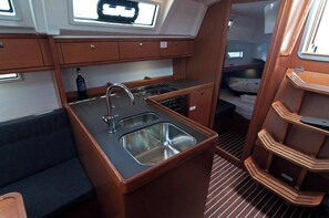 A compact galley with a sink, stove, and storage cabinets. - Sun-Kissed Sailing Adventure in Split, Croatia (Split)