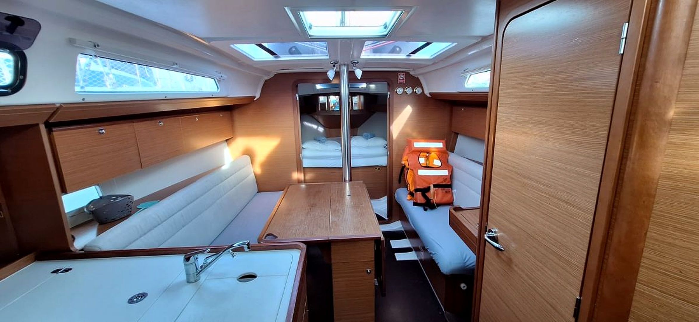 A compact interior with a bunk bed, a small table, and a sink.
