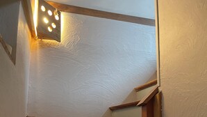 Een trap met houten treden en een lamp aan de muur.