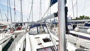 A marina with multiple boats docked, a clear sky, and a flag on one boat. - Sun-Kissed Sailing Adventure in Zadar, Croatia (Bibinje)