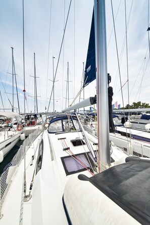 A marina with multiple boats docked, a clear sky, and a flag on one boat. - Sun-Kissed Sailing Adventure in Zadar, Croatia (Bibinje)
