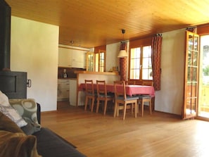 A cozy interior with a dining area, kitchen, and a sofa.