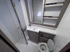 A compact bathroom with a toilet, sink, and mirror. - Sun-Kissed Sailing Adventure in Zadar, Croatia (Bibinje)