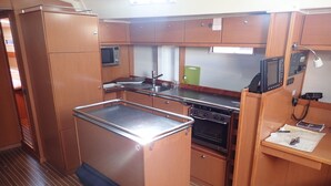 A compact kitchen with a microwave, oven, and a small sink. - Sun-Kissed Sailing Adventure in Zadar, Croatia (Bibinje)