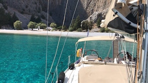 A boat with a steering wheel, ropes, and a canopy.