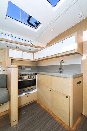 A compact kitchen with a skylight, a stove, and a sink. - Sun-kissed Sailing Adventure in Split-Dalmatia, Croatia (Trogir)