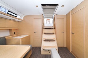 A compact interior with a bed, a small table, a bench, and a wardrobe. - Sun-kissed Sailing Adventure in Split-Dalmatia, Croatia (Trogir)