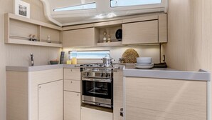 Une cuisine compacte dotée d’un four encastré, d’un évier et d’un plan de travail.