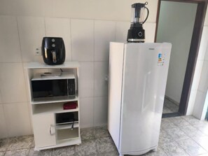 A kitchenette with a coffee maker, a microwave, and a refrigerator. - Sollegria House: Inclusive, Swimming Pool, BBQ, Pets, Businesses and Groups (Montes Claros)