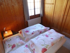 A small, single-bed room with wooden walls and a window. - Guex Appartement/Fewo, Dusche oder Bad, WC 5-Bettwohnung by Interhome (Gstaad)