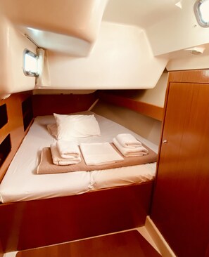 A compact cabin with a single bed, neatly made with towels and pillows. - Sun-Kissed Sailing Adventure in the Ionian Islands, Lefkada (Lefkada)