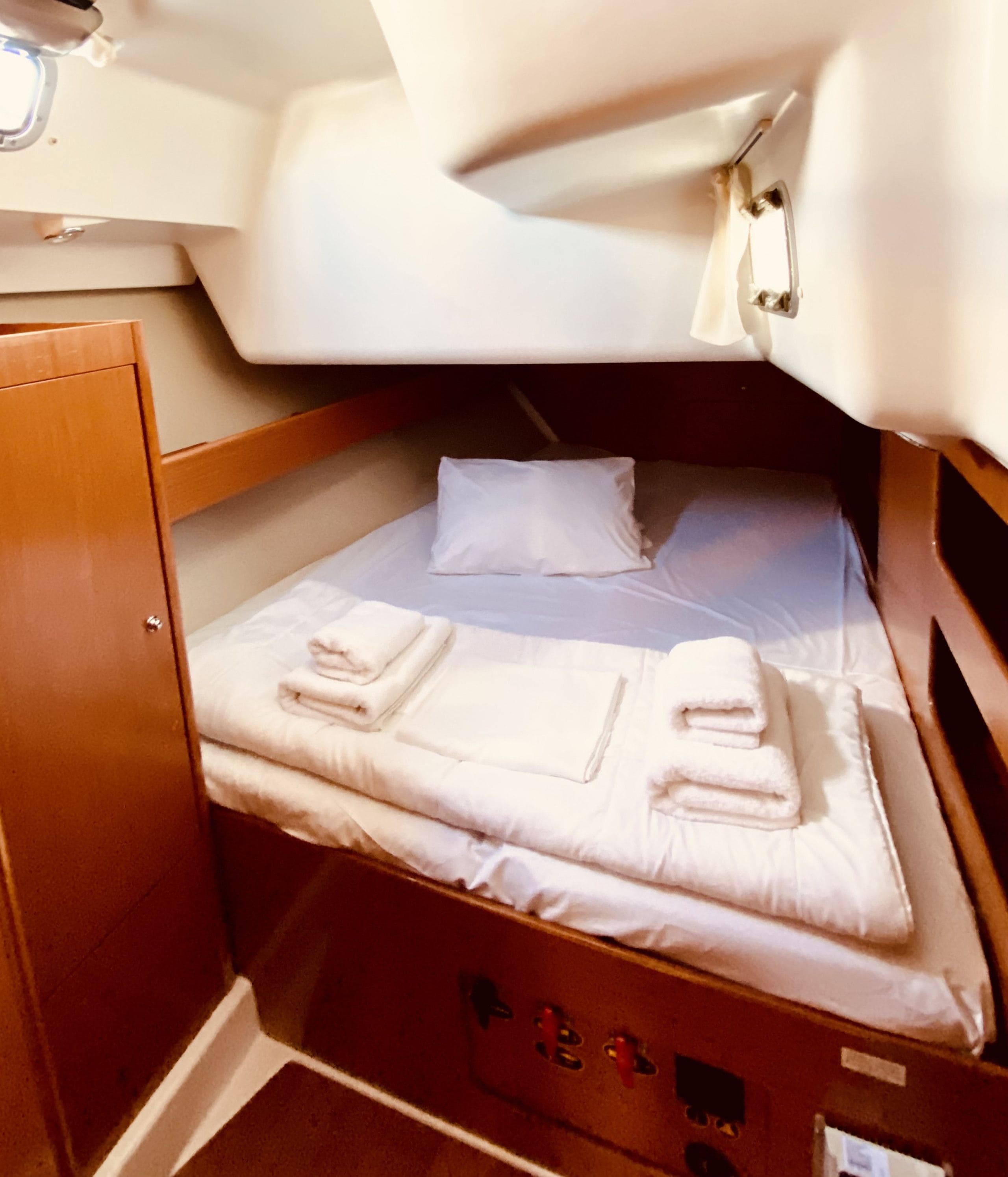 A compact cabin with a bunk bed, a small cabinet, and a control panel.