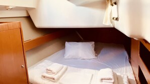 En kompakt hytte med køjeseng, et lille skab og et kontrolpanel.