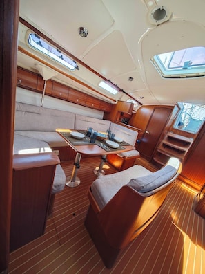 A compact galley with a dining table, cushioned seating, and a small kitchen area. - Sun-kissed Sailing Adventure in the Ionian Islands (Preveza)
