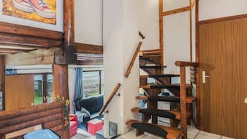 Un escalier en bois avec une rampe, une porte et une fenêtre donnant sur l’extérieur.