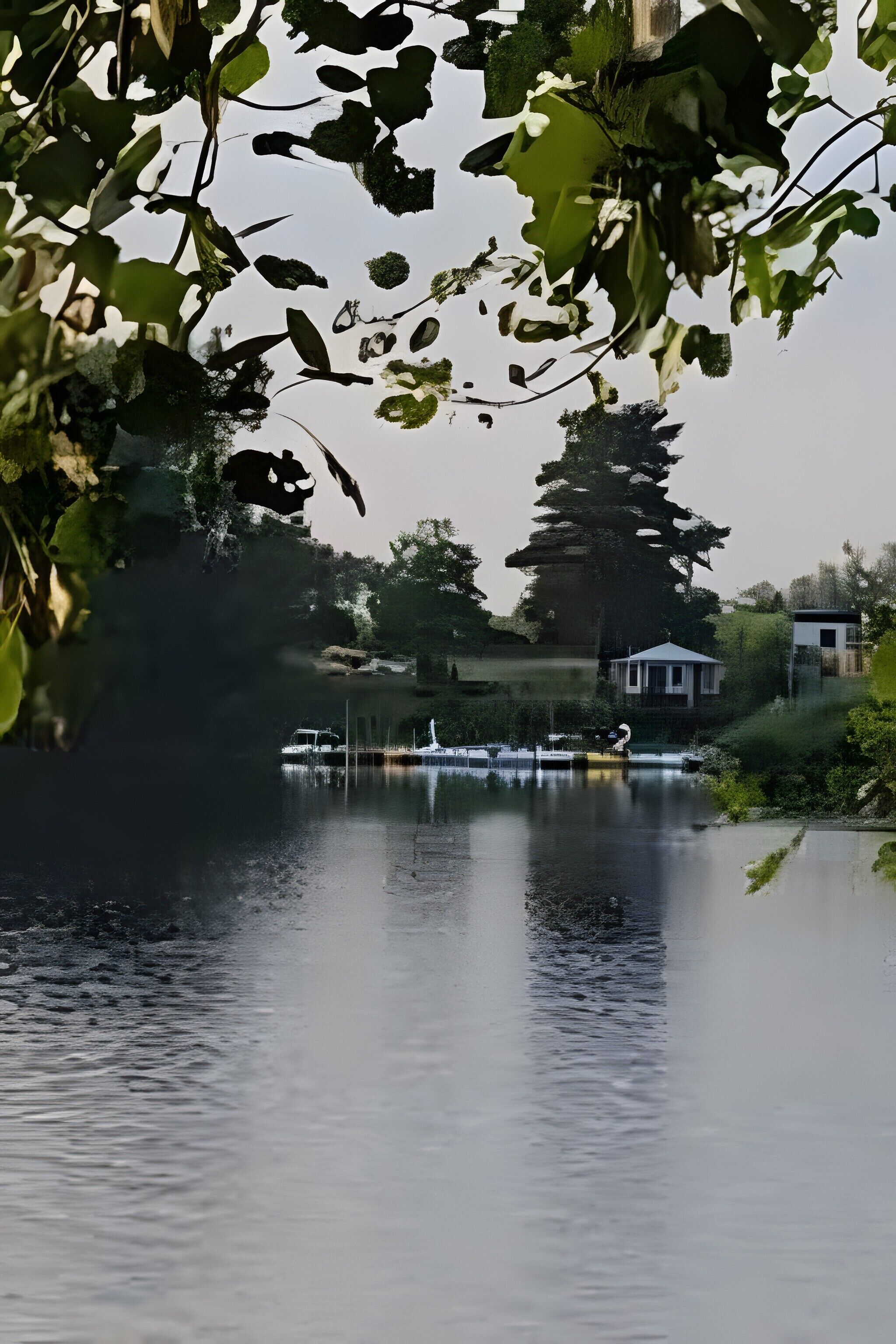 En stilla sjö med båtar, en lusthus och ett hus i bakgrunden.