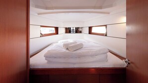 A compact, well-lit cabin with a single bed, wooden headboard, and a view through a window. - Sun-Kissed Sailing Adventure in Split, Croatia (Split)