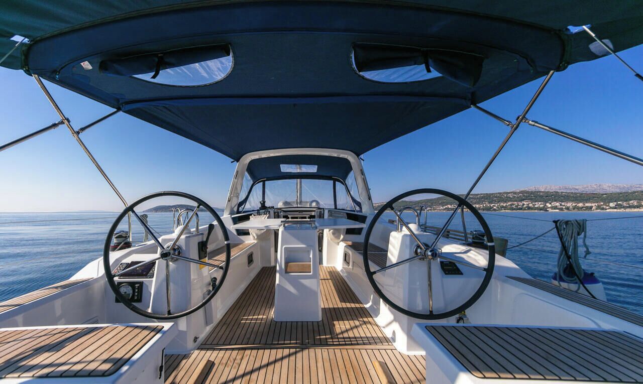 A boat deck with a steering wheel, a table, and a canopy.