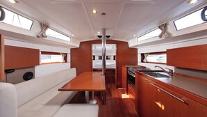 A compact kitchen with a dining area, wooden cabinets, and a central column. - Sun-Kissed Sailing Adventure in Split, Croatia (Split)