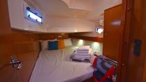 A compact cabin with a bed, a small table, and a window with a view. - Sun-Kissed Sailing Adventure in the Sporades Islands from Volos, Thessaly (Volos)