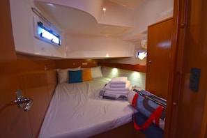 A compact cabin with a bed, a small table, and a window with a view. - Sun-Kissed Sailing Adventure in the Sporades Islands from Volos, Thessaly (Volos)