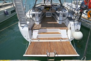 A boat's deck with a wooden floor, a steering wheel, and a Suzuki outboard motor. - Sun-Kissed Sailing Adventure in the Sporades Islands from Volos, Thessaly (Volos)