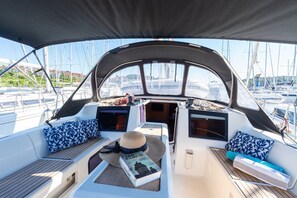 Ein Bootsdeck mit Sitzgelegenheiten, einem Hut und einem Buch.