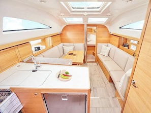 A compact, well-lit interior with a kitchenette, seating area, and skylights. - Sun-Kissed Sailing Adventure in Northern Croatia (Punat)