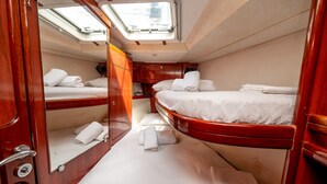 A compact cabin with two beds, a small seating area, and a skylight. - Sun-Kissed Sailing Adventure in Islas Sarónicas (Alimos)