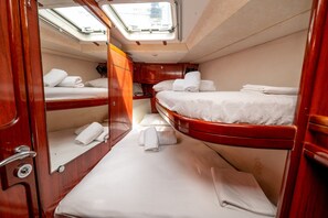 Ein gemütliches Blockhaus mit zwei Betten, einer kleinen Sitzecke und einem Dachfenster.