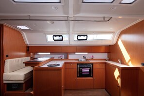 A compact kitchen with a built-in oven, a sink, and a small dining area. - Sun-Kissed Sailing Adventure in Split, Croatia (Split)