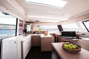 Eine moderne Küche mit einer großen Kochinsel, einem Flachbildfernseher und Blick auf das Wasser.