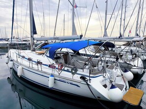 A marina with multiple sailboats docked, featuring a covered deck area and various navigational equipment. - Sun-Kissed Sailing Adventure in Northern Croatia (Punat)