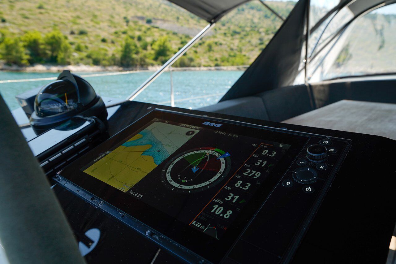 A boat's control panel with a digital map, compass, and various gauges.