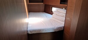 A compact, wooden interior with a single bed, a small window, and built-in storage. - Sun-Kissed Sailing: An Unforgettable Beach Experience in Istria, Croatia (Medulin)