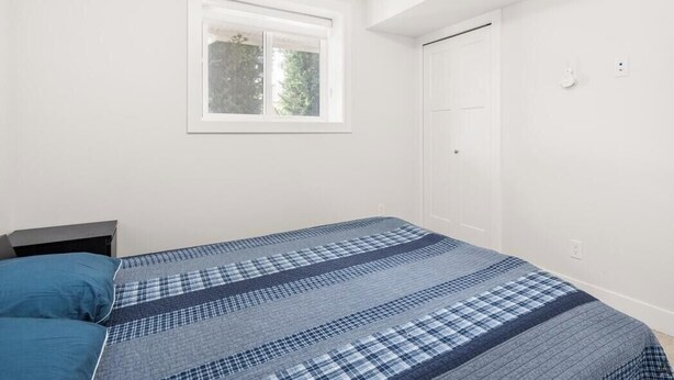Ein Schlafzimmer mit Bett, Fenster und Tür.