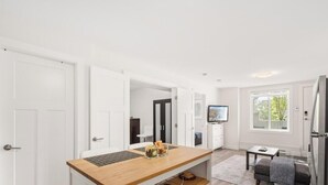 Eine moderne Küche mit weißen Schränken, einer Holz Arbeitsplatte und einem eingebauten Ofen.