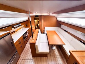 Un intérieur compact et bien éclairé, comprenant un coin cuisine, un espace salon et une petite table.