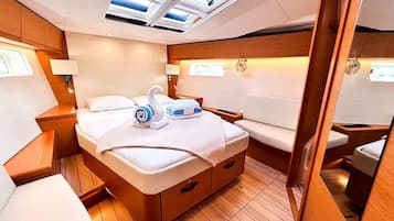 Une chambre moderne et bien éclairée, avec un grand lit, des tables de chevet et une lucarne.