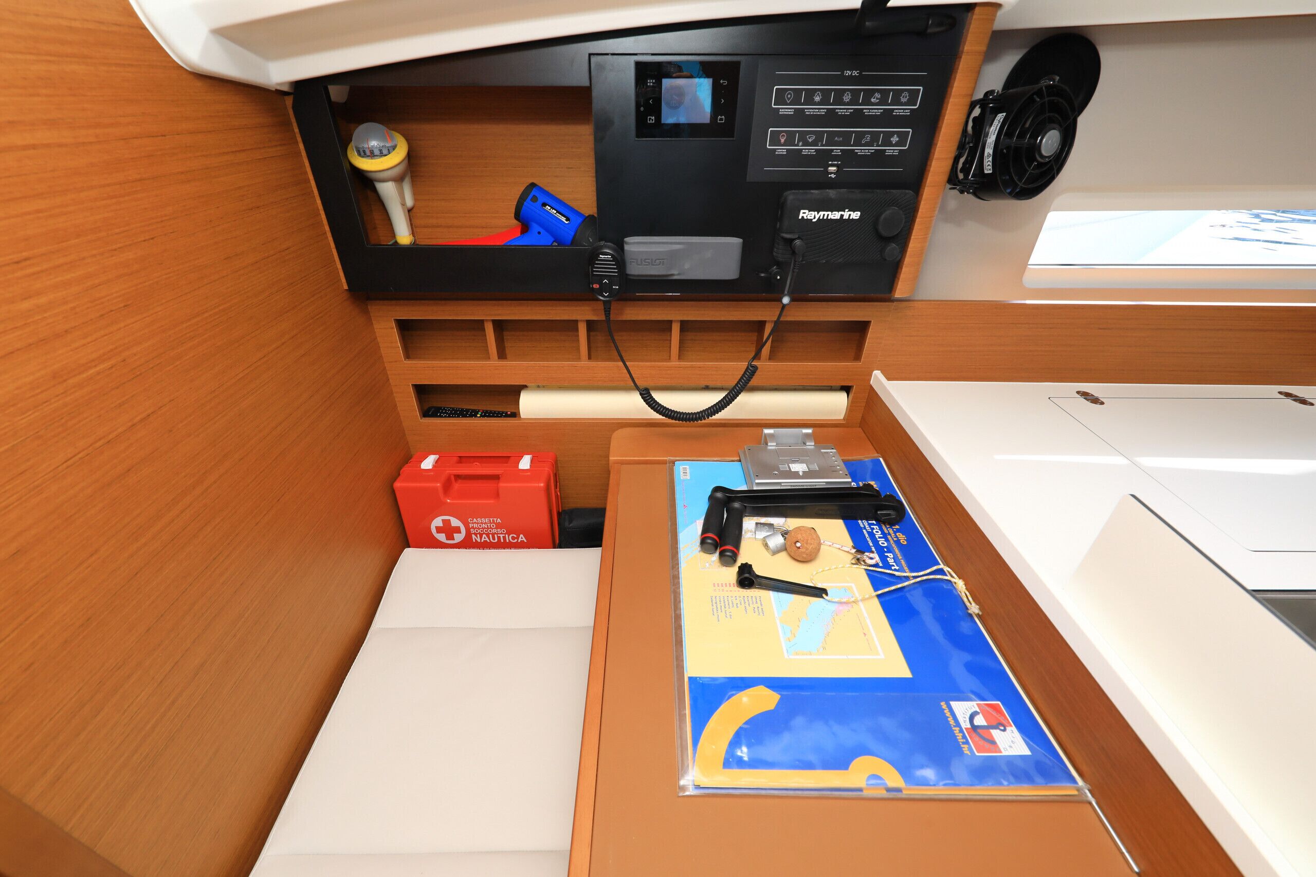Un panneau de commande doté d’un écran, d’un appareil Raymarine et d’une boîte rouge portant l’inscription « Nautica ».