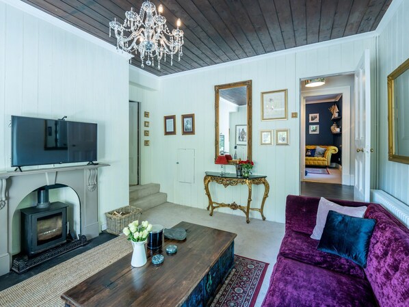 A living room with a fireplace, television, and a large mirror.