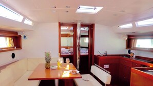 Een compact interieur met een eethoek, een kleine kitchenette en een zithoek met uitzicht op het terras.