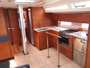A compact kitchen with wooden cabinetry, a stainless steel stove, and a sink.