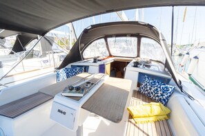 A boat's deck with a table, cushions, and a B&G appliance. - Sun-Kissed Sailing Adventure in Istria, Croatia (Pula)