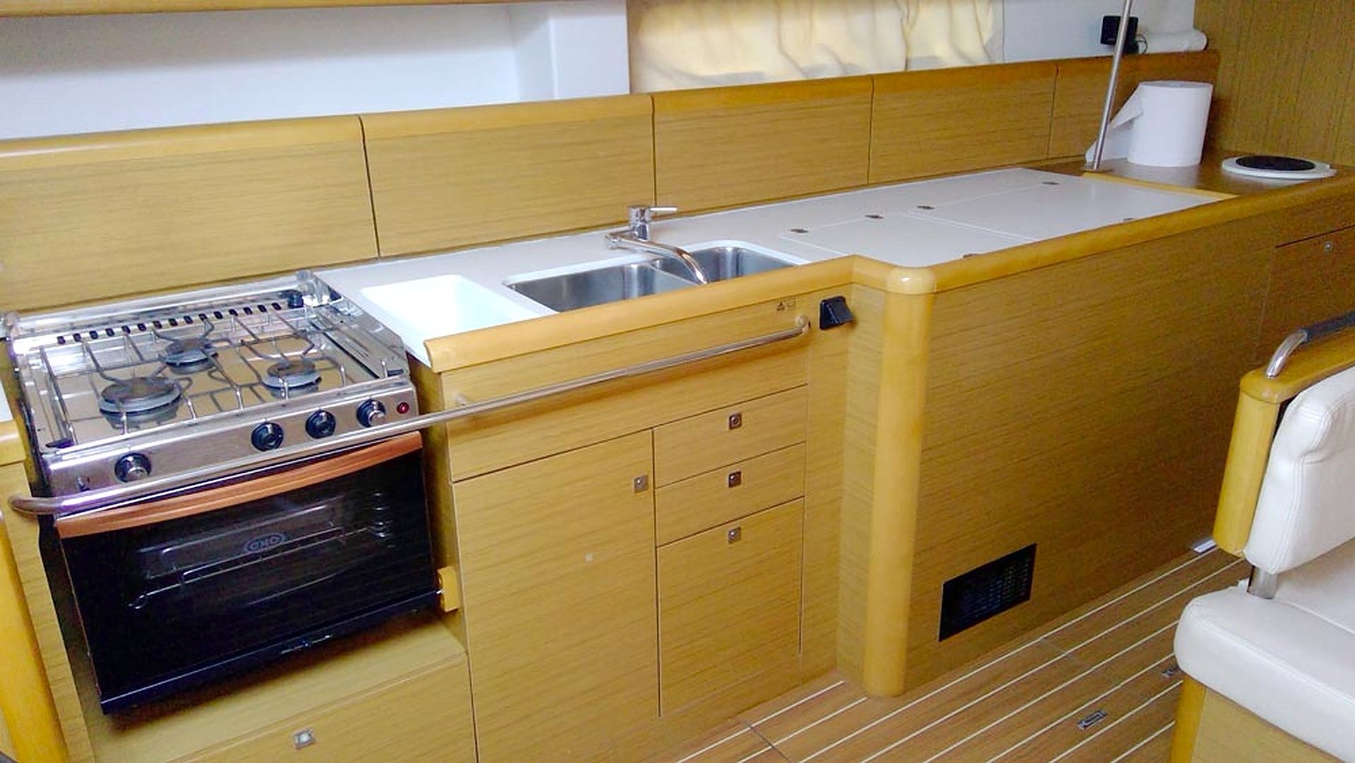 Une petite cuisine équipée avec une cuisinière à gaz, un four, un évier et des placards en bois.