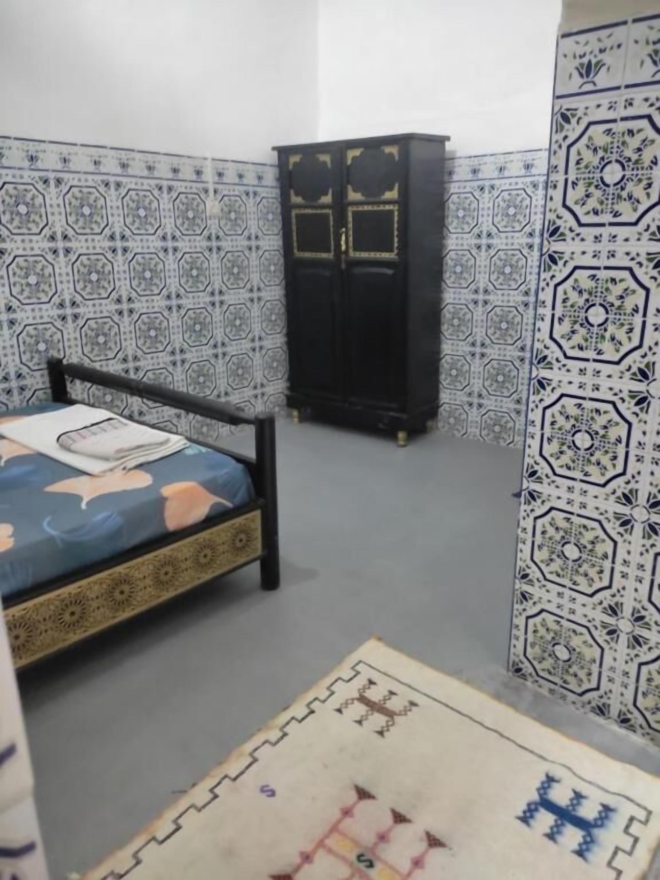 Una habitación con cama, armario y paredes con diseño.