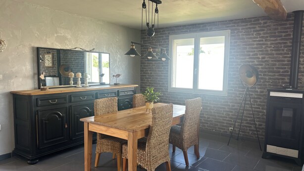 A kitchen with a dining table and chairs, a large window, and a brick wall. - A bright vacation rental in the heart of the countryside, near the Baie de Somme (Vron)
