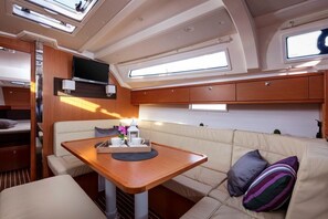 A cozy interior with a cushioned seating area, a wooden table, and a television mounted on the wall. - Sun-Kissed Sailing Adventure in Split, Croatia (Split)