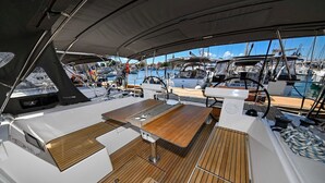 A boat deck with a table, seating, and a view of other boats in the marina. - Sun-Kissed Sailing Adventure in Zadar, Croatia (Zadar)